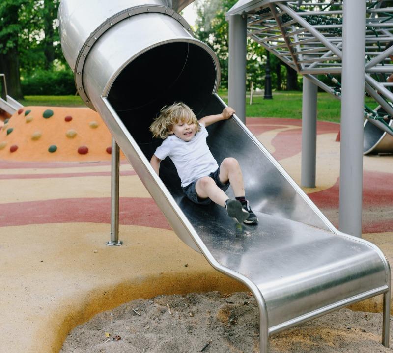 Kid Sliding Down Slide in Park